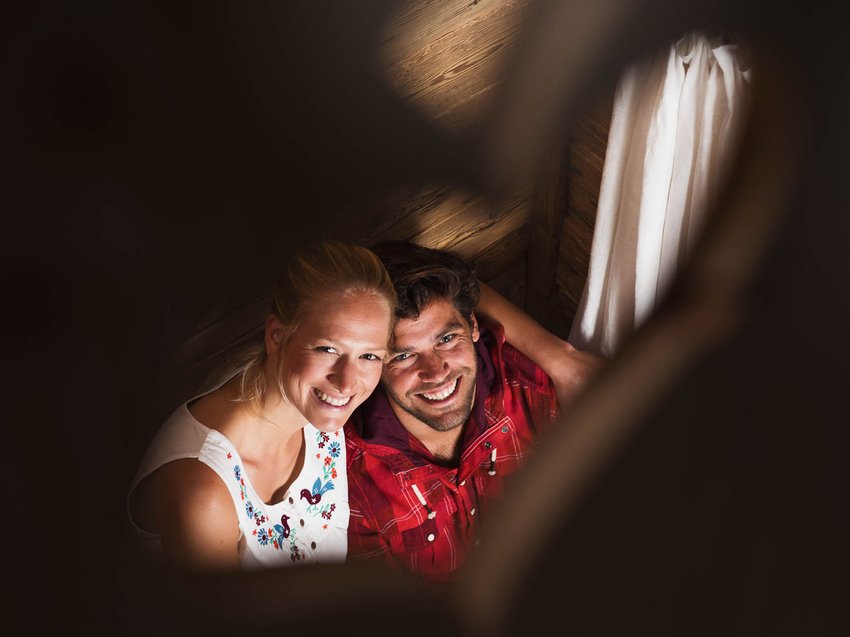 Get away from it all and relax at our chalet in Stubaital Smiling couple in a wooden cabin photographed through a heart-shaped object