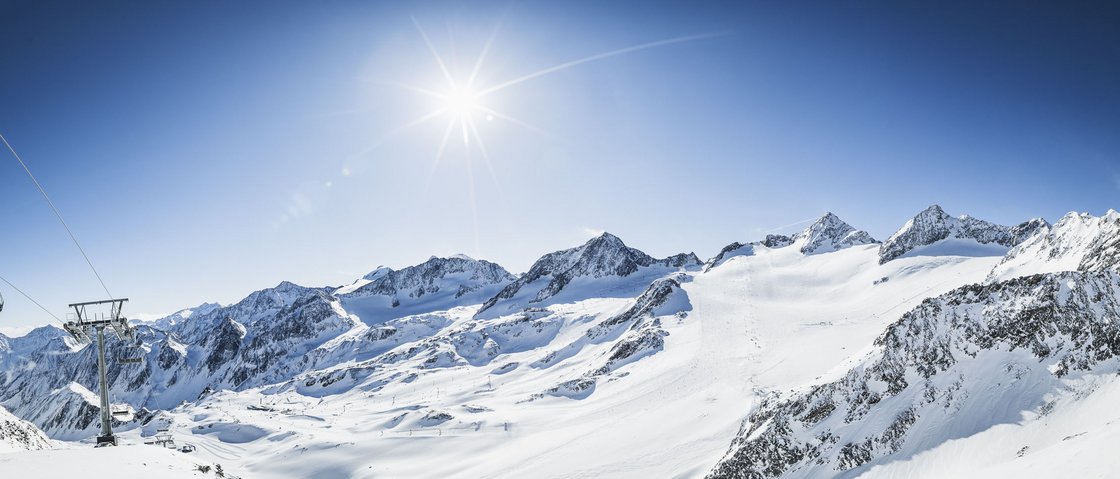 Your unforgettable ski holiday in Stubaital Snow-covered mountains with ski lift under clear sky and bright sun