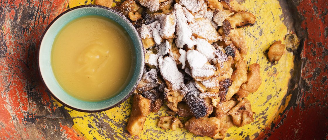 Culinary indulgence all across Stubaital Kaiserschmarrn with powdered sugar and applesauce in a colorful bowl